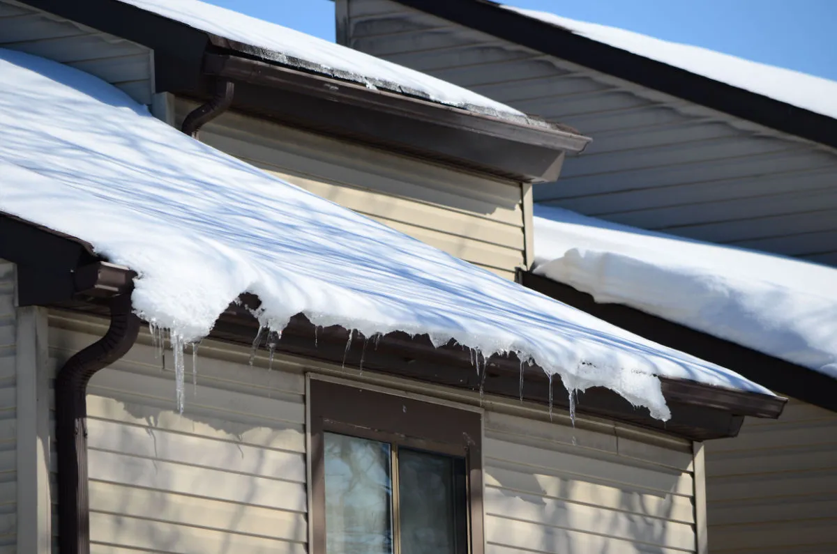 Ice dams and icicles forming on the roof edge of a home in Newark, New Jersey during winter