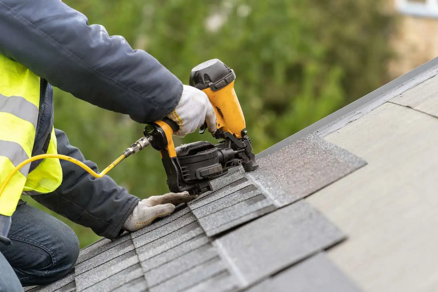 Professional roofer fixing roof leak in New Jersey using nail gun – roof repair and maintenance