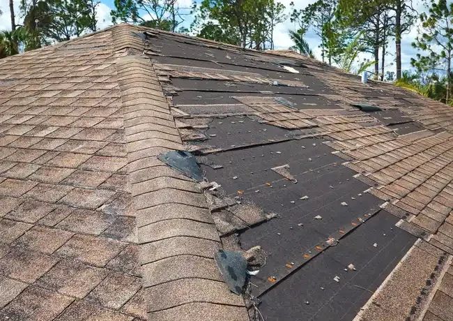 Roof damaged by strong storm in New Jersey missing shingles and exposed underlayment