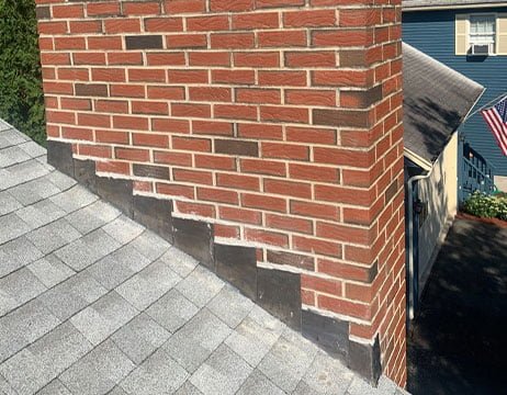 Damaged roof flashing being repaired by licensed contractor in NJ